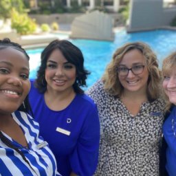 Delta Hotels staff smiling in front of pool