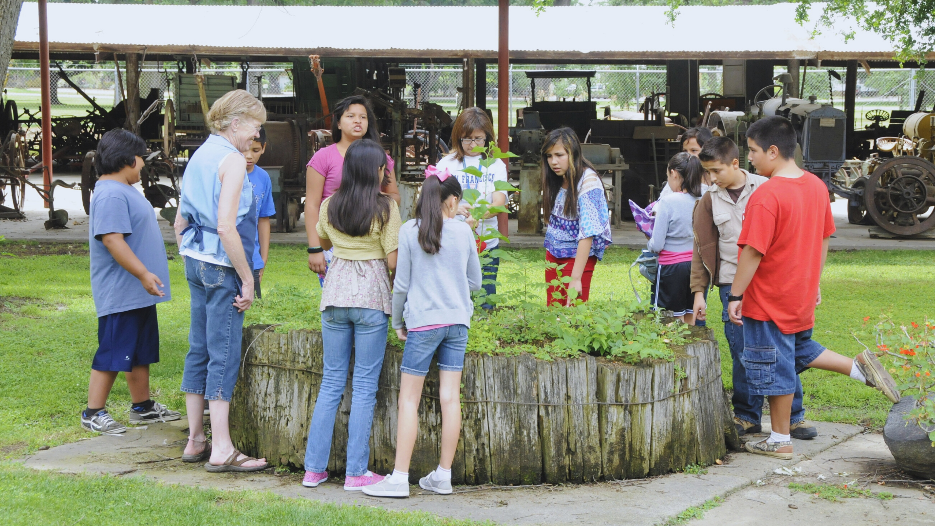 children with tour guide looking at the plants